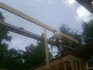 Carpenter setting a ridge beam over a new addition frame — Ice Dam Removal by Roofing Brothers in Baxter Springs