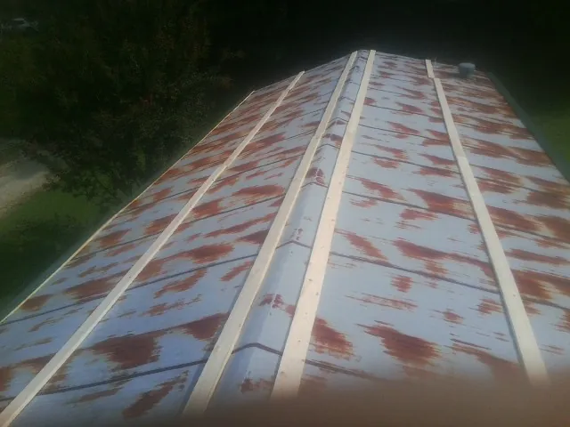 Rusted metal roof panels with new wood purlins before replacement — Storm Damage Roof Repair in Baxter Springs by Roofing Brothers