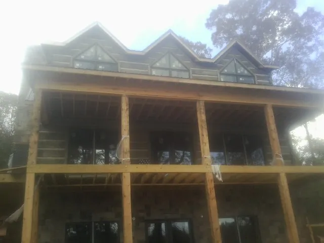 Dormers and porch framing on a large log home under construction — Roof Coating work by our crew in Baxter Springs